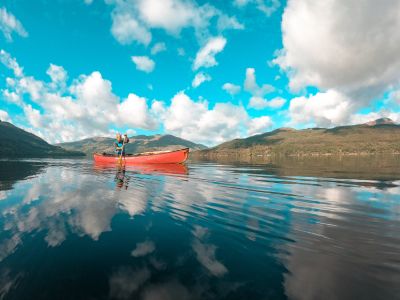 A man paddling a canoe on a loch