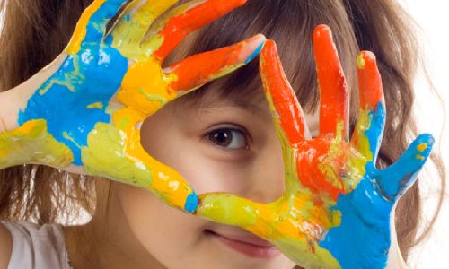 A young girl with paint on her hands